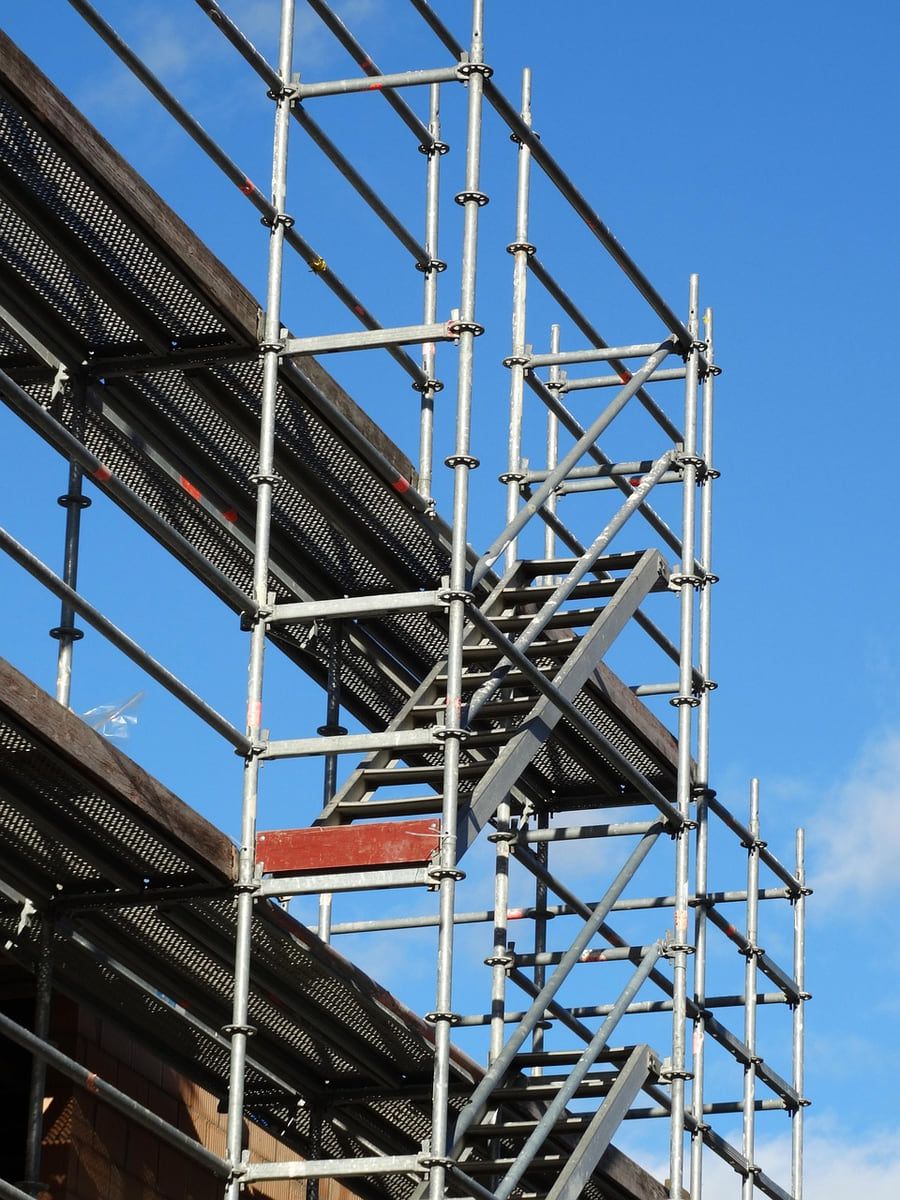 Gerüst mit einem Treppenlauf vor blauem Himmel, von unten gesehen